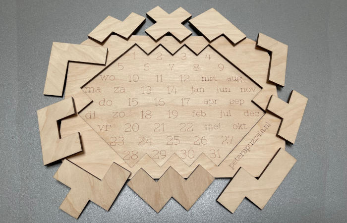 Foto van een leeg bord van kalenderpuzzel "Ruit" met alle 10 stukken eromheen
